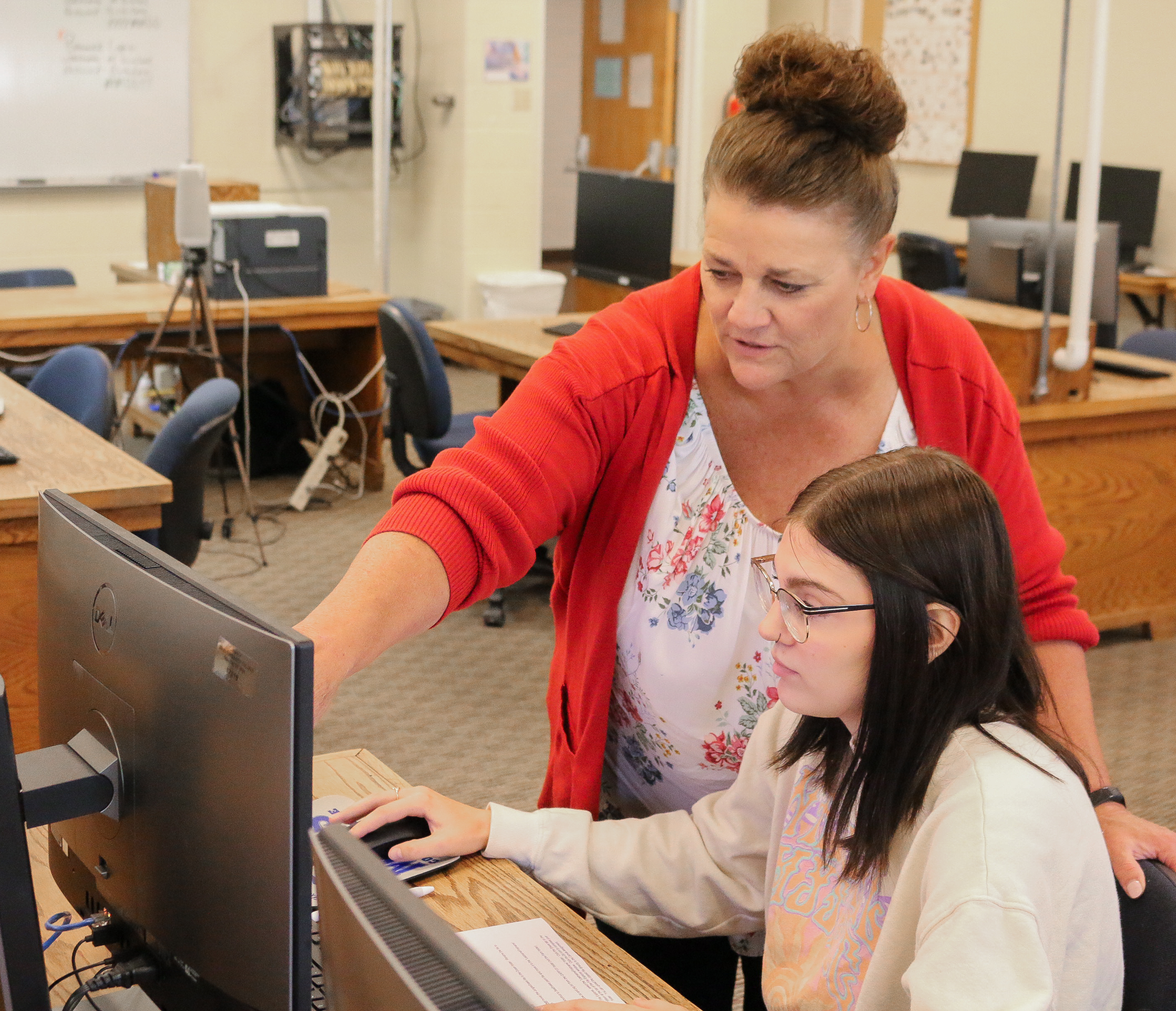 Adult helping student on computer