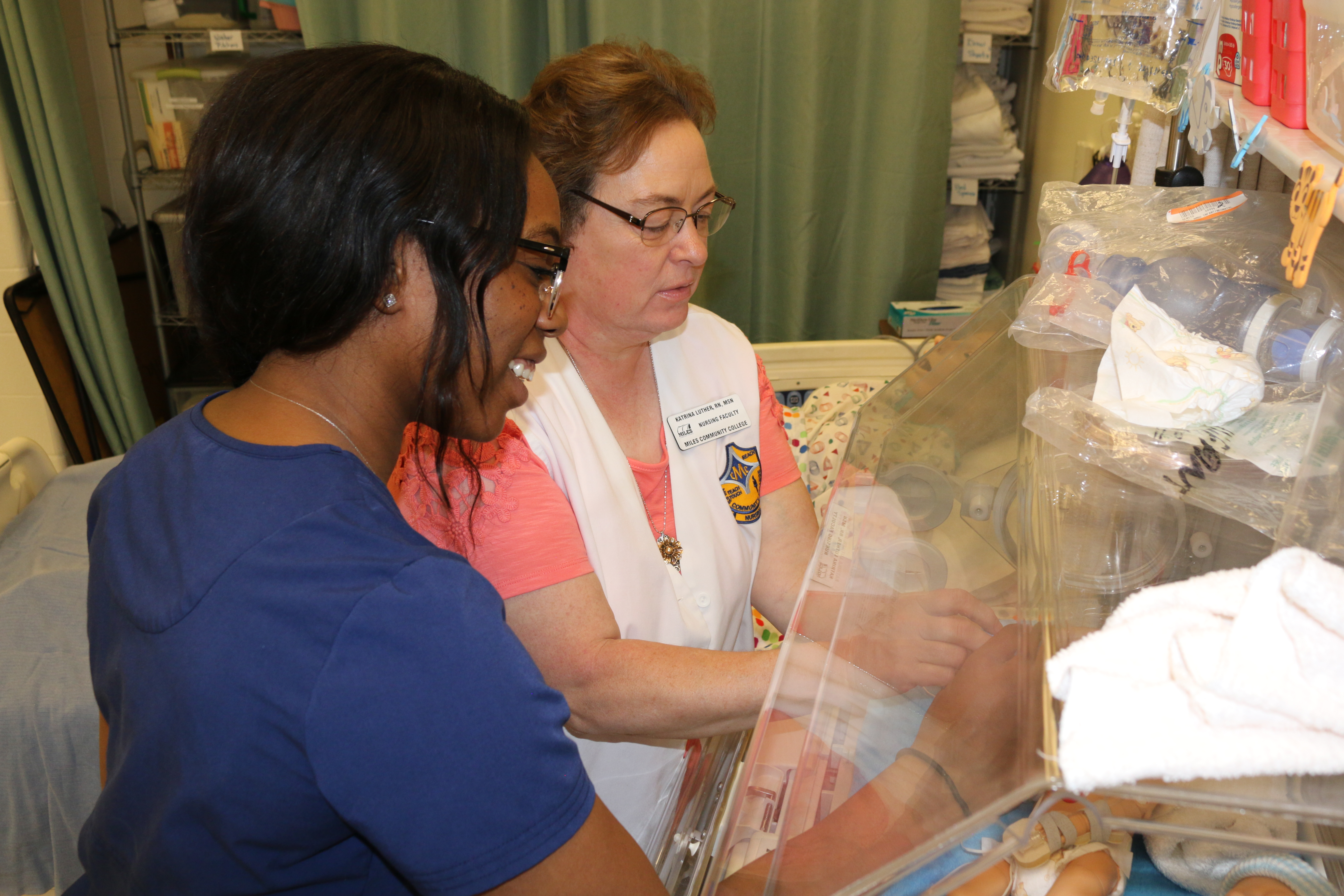 Image of two females looking at clear case in nursing lab